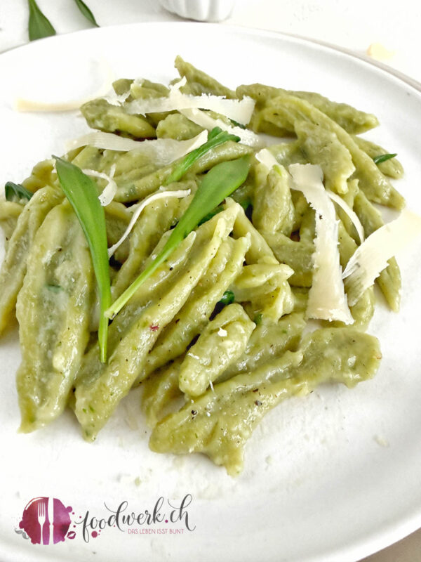 Schnelle Bärlauch- Scherennudeln 1 Frische Bärlauch Schrennudeln auf weissem Teller mit geraspeltem Käse und frischen Bärlauchblätter